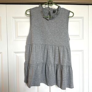 light grey tank top blouse with loose fitting and ruffles around neck line.